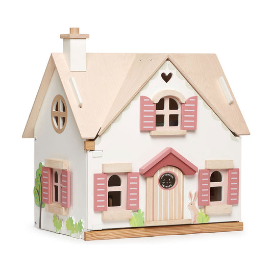 Wooden toy house with pink shutters and a white base on a white background, tender leaf doll house